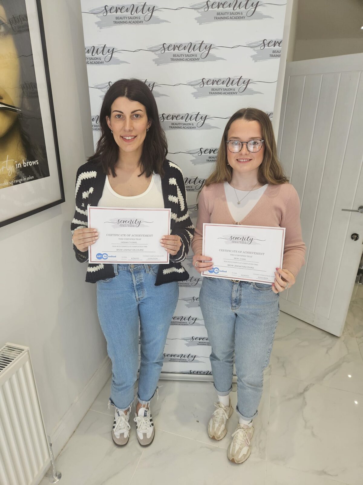 Two Serenity Training Academy graduates holding their brow lamination certificates