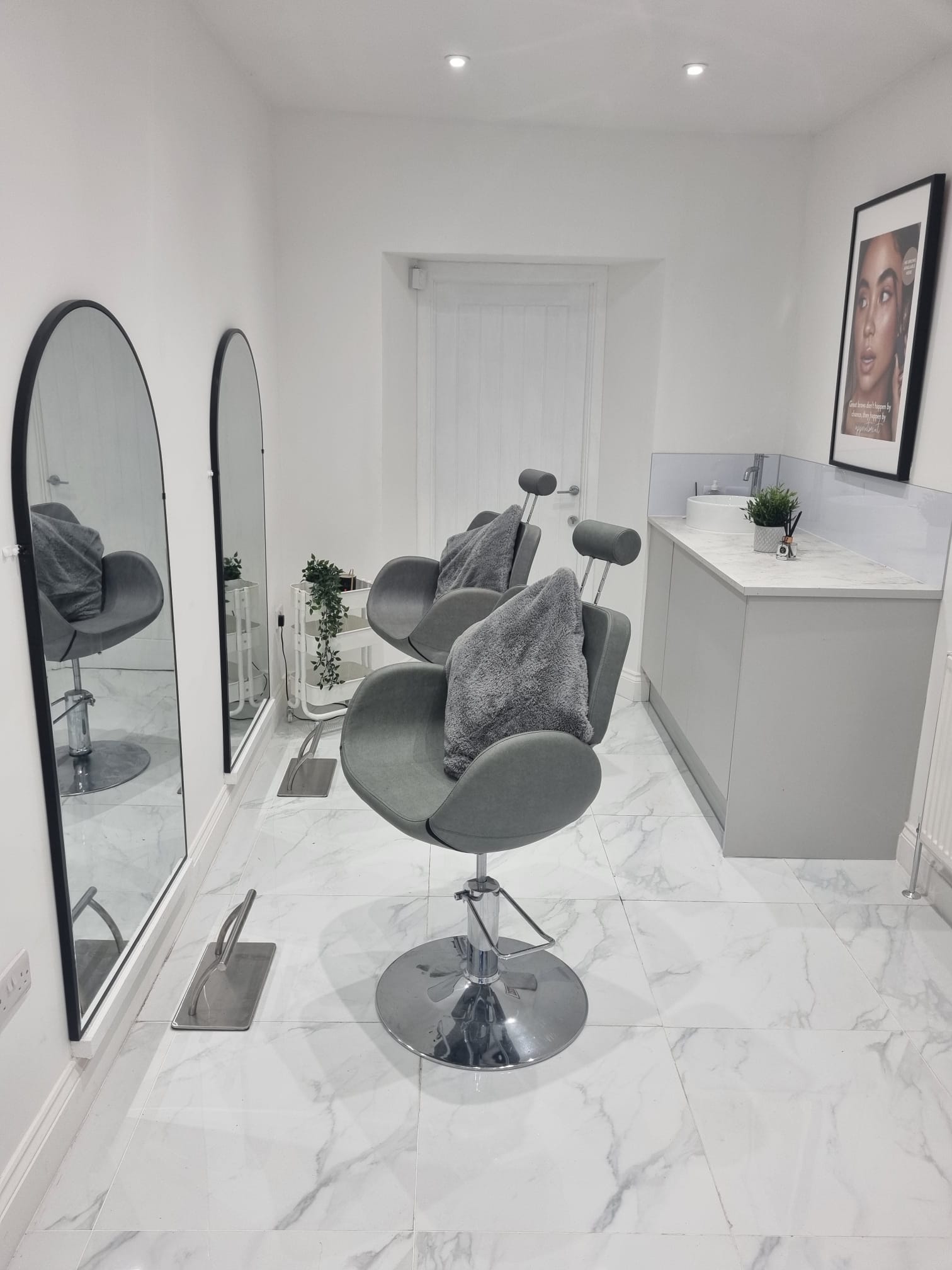 Treatment room at Serenity Beauty Salon in Cardigan with grey reclining chairs and arched mirrors